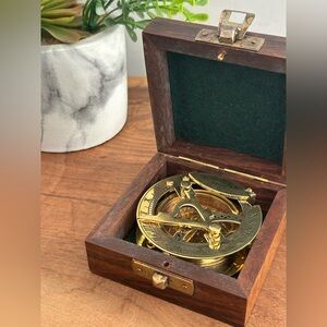 Decorative brass sundial compass in a wooden box. Navigate educate.